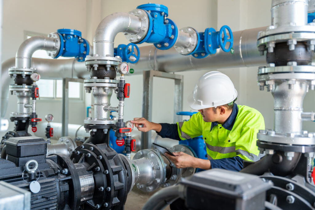 Techniker bei der Wartung von Pumpen und Rohrleitungen in einer Industrieanlage