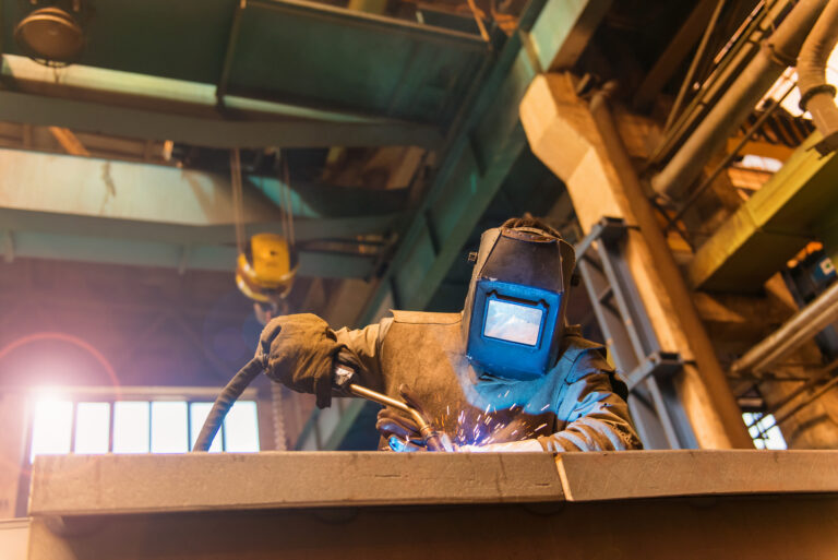 Schweißfachkraft beim Schweißen eines Stahlbauteils in der Werkstatt