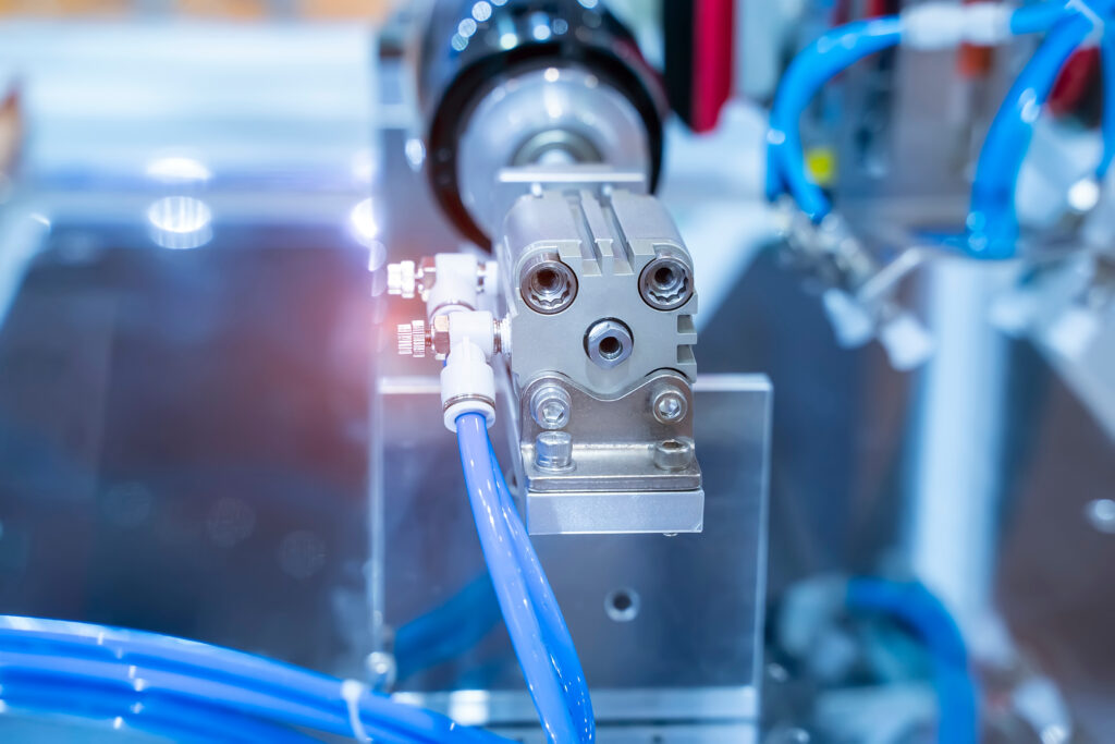 Pneumatikzylinder mit Druckluftleitungen in einer Produktionsanlage
